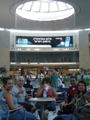 Nicole, Bill, Nina, Karim, and oum Fadi waiting in Tel Aviv airport for flight to Paris and home, with lovely waterfall fountain behind (rw)