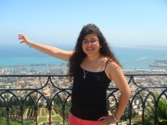 Hope with Haifa Harbor and the Baha'i Shrine of the Bab behind her (ms)